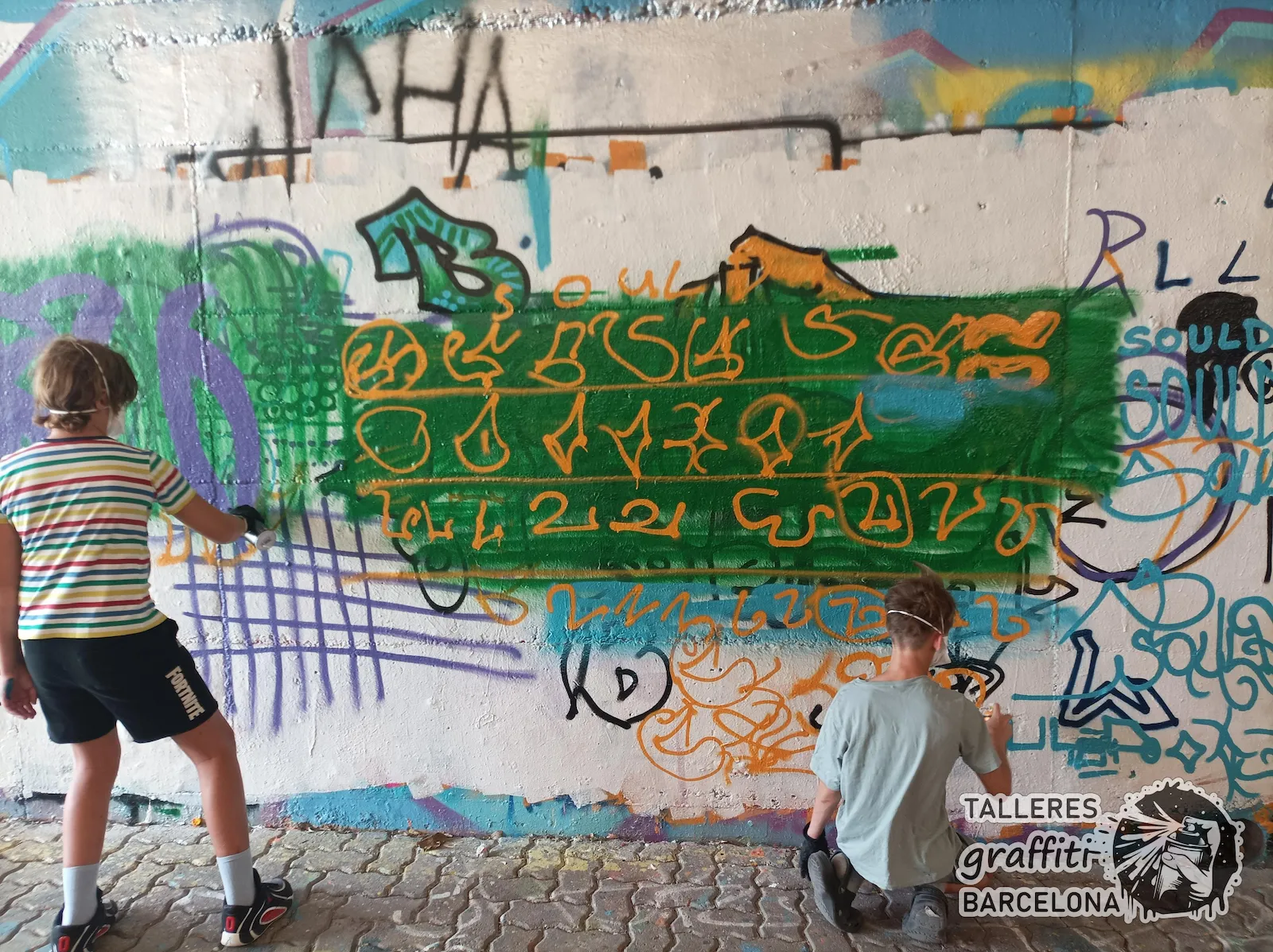 Alumnos adolescentes practicando letras de graffiti con spray en Barcelona