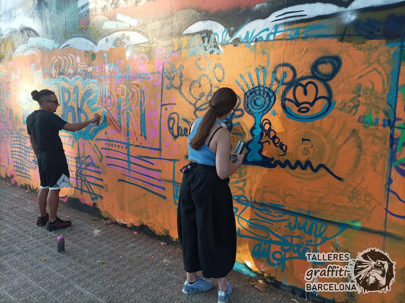 Alumna joven pintando graffiti con spray en un curso en Barcelona